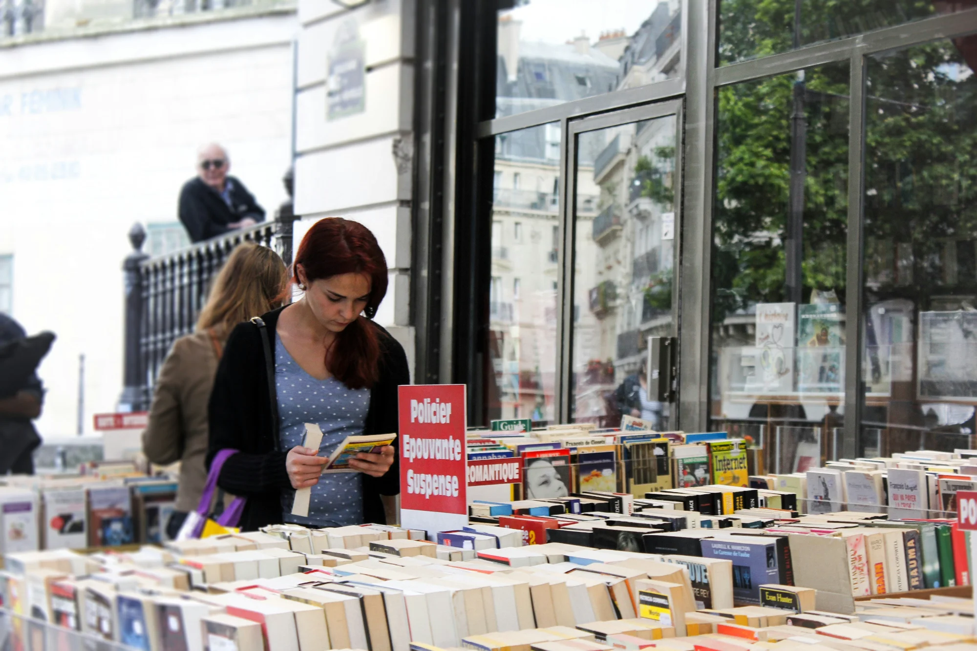 Lectrice feuilletant des livres dans une librairie parisienne